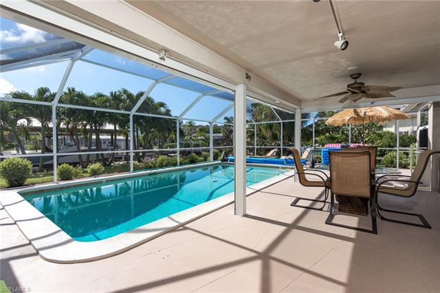 8522 Lagoon Road Fort Myers Beach, FL 33931 - Photo 16 of 32 Screened salt water heated pool, great for entertaining and enjoy the gorgeous view of the Canal and landscape.