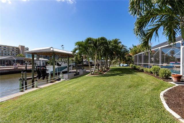 8522 Lagoon Road Fort Myers Beach, FL 33931 - Photo 5 of 32 Meticulously manicured extra wide backyard with plenty of palm trees overlooking your Boat and Canal.