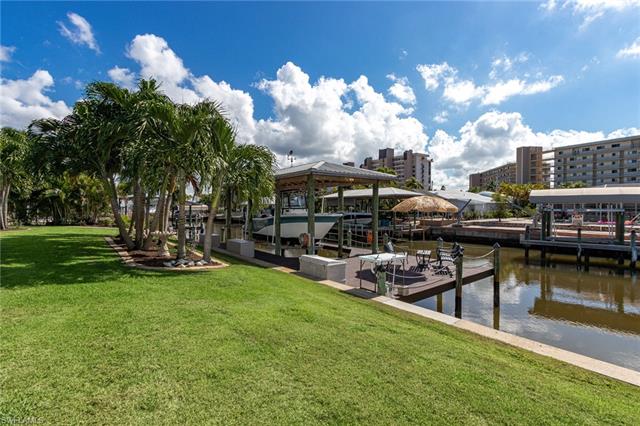 8522 Lagoon Road Fort Myers Beach, FL 33931 - Photo 8 of 32 Wide Canal, Big dock with boat lift and metal roof canopy, fish cleaning station, sitting area to enjoy quiet evenings, over sized backyard beautifully landscaped