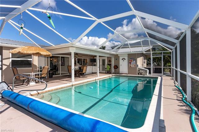 8522 Lagoon Road Fort Myers Beach, FL 33931 - Photo 9 of 32 Enjoy the Sun or cool off under the covered patio, equipped with a mini fridge, wine cooler, TV. and dry bar, direct access to 2nd. bathroom for convenience.