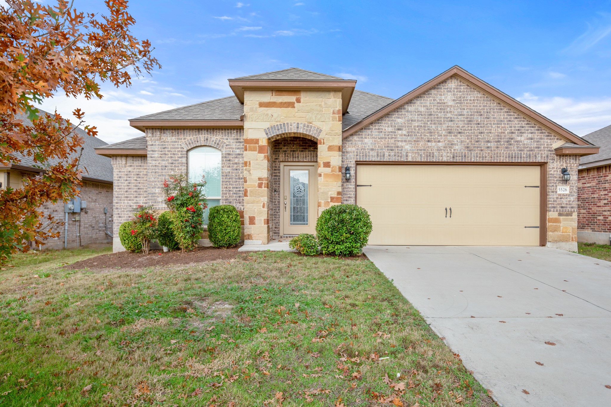 5526 Perdita Drive Belton, TX 76513 - Photo 2 of 26 French country home featuring brick siding, an attached garage, concrete driveway, roof with shingles, and a front lawn