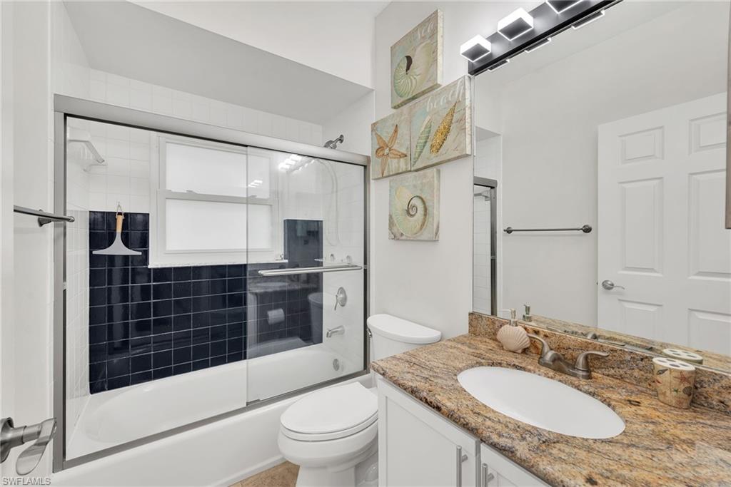 181 Napa Ridge Road East, Unit 35 Naples, FL 34119 - Photo 15 of 21 Bathroom featuring a white tub with dark tiled surround and sliding glass doors