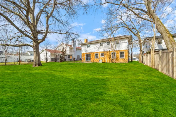 a view of a building with a big yard with large trees