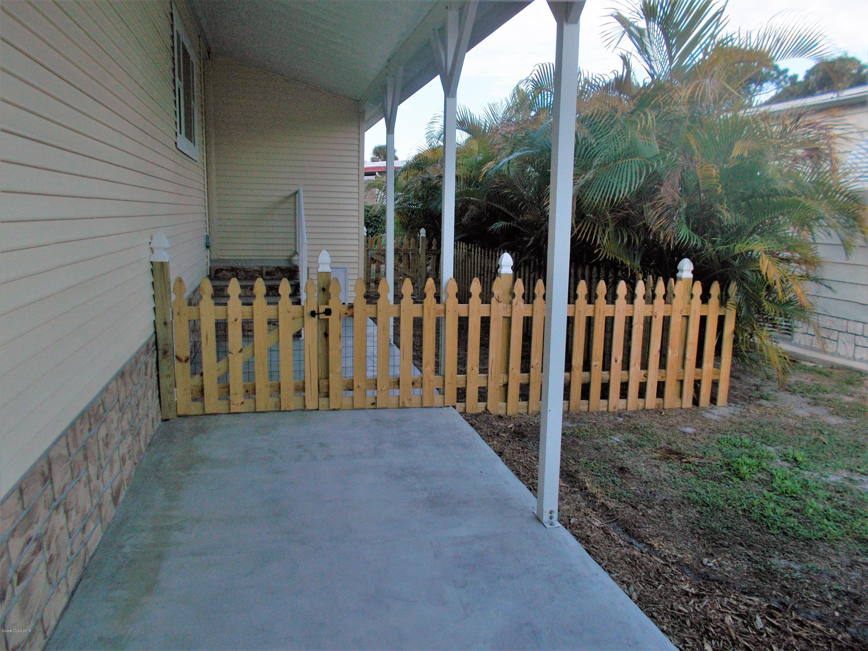 1054 Sebastian Road Barefoot Bay, FL 32976 - Photo 22 of 24 SIDE OF HOME LEADING TO UTILITY SHED