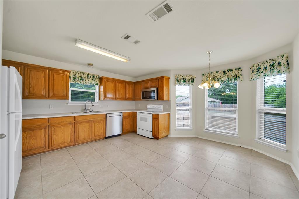 4221 Fiste Denton, TX 76207 - Photo 13 of 26 Kitchen featuring pendant lighting, appliances with stainless steel finishes, sink, a chandelier, and light tile patterned flooring