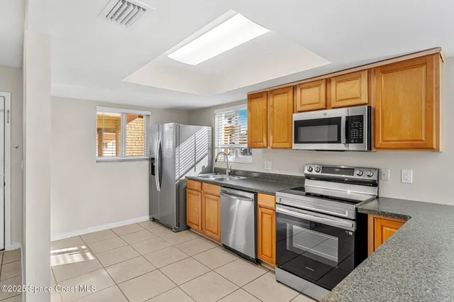 a kitchen with stainless steel appliances granite countertop a stove a sink and a microwave