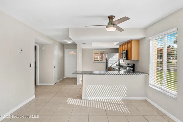 a living room with stainless steel appliances kitchen island granite countertop furniture and a window