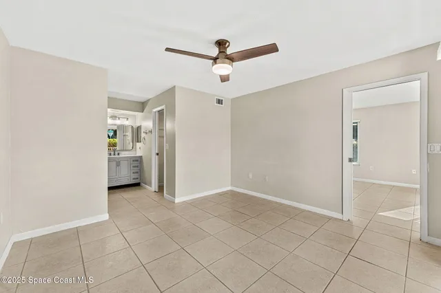 a view of empty room with wooden floor and ceiling fan