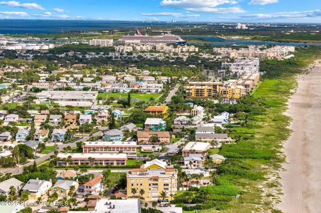 an aerial view of residential houses with outdoor space and ocean view
