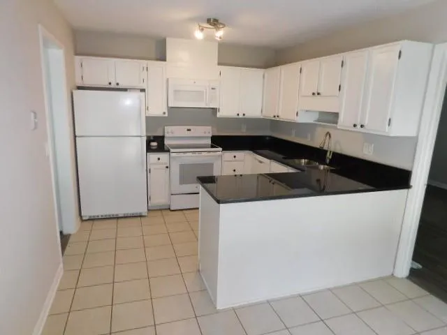 a kitchen with cabinets and white appliances