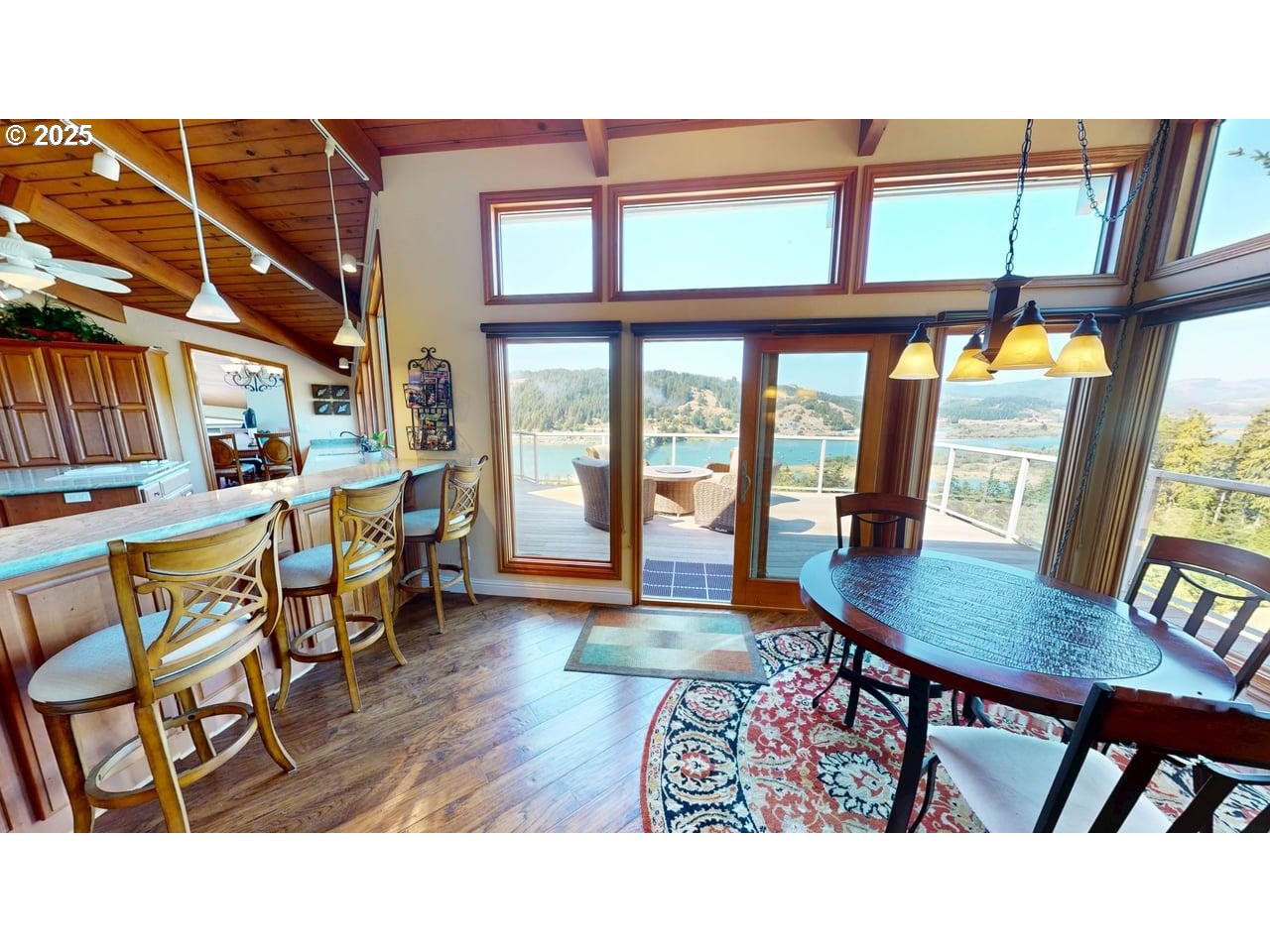 94418 Tom Cat Hill Road Gold Beach, OR 97444 - Photo 13 of 46 a dining room with furniture a rug and wooden floor