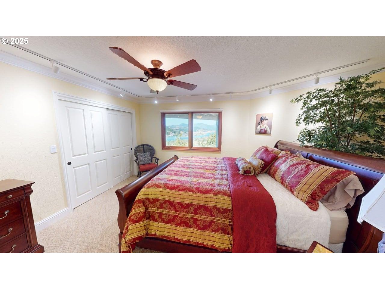 94418 Tom Cat Hill Road Gold Beach, OR 97444 - Photo 23 of 46 a bedroom with a bed and a chandelier