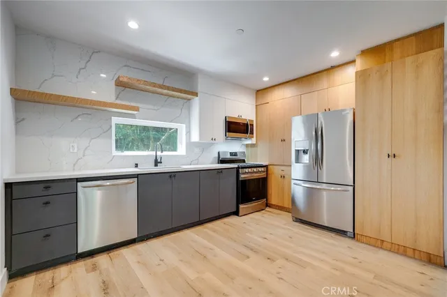 a kitchen with stainless steel appliances a refrigerator sink and cabinets