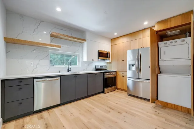 a kitchen with a refrigerator a sink a stove a microwave and wooden floor