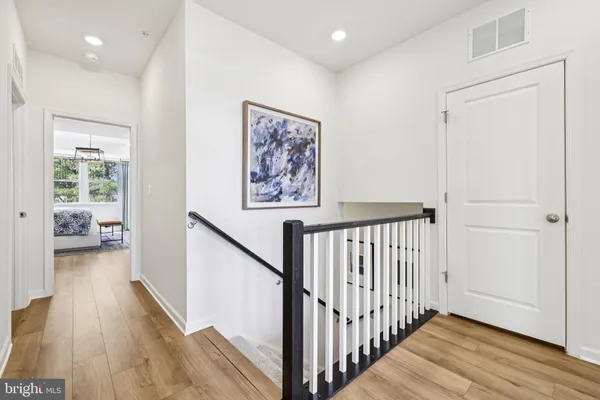 a view of a hallway with wooden floor and furniture