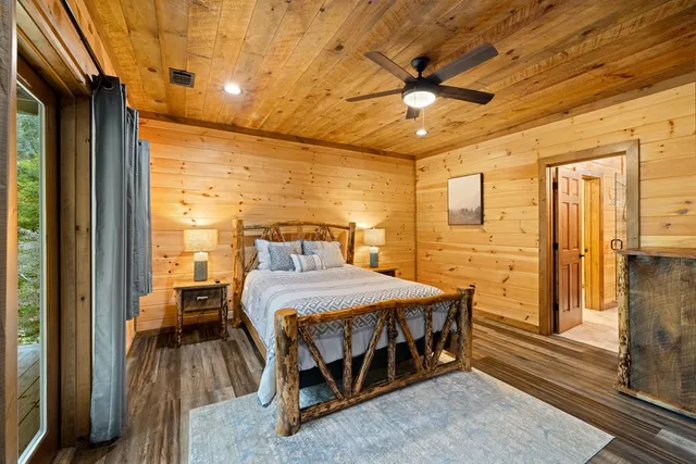 a bedroom with a large bed and a flat tv screen on dresser