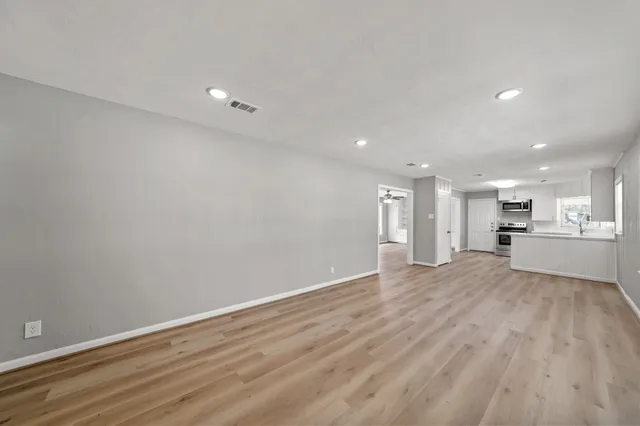 a view of empty room with wooden floor