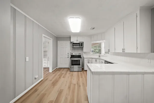 a kitchen with sink cabinets and stainless steel appliances