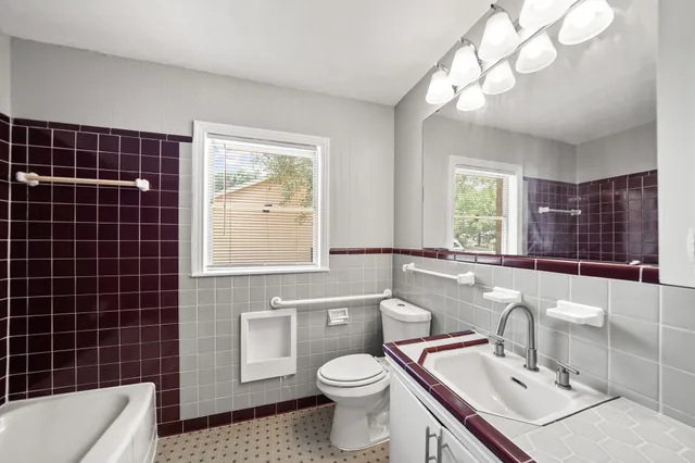 a bathroom with a sink toilet mirror and tub
