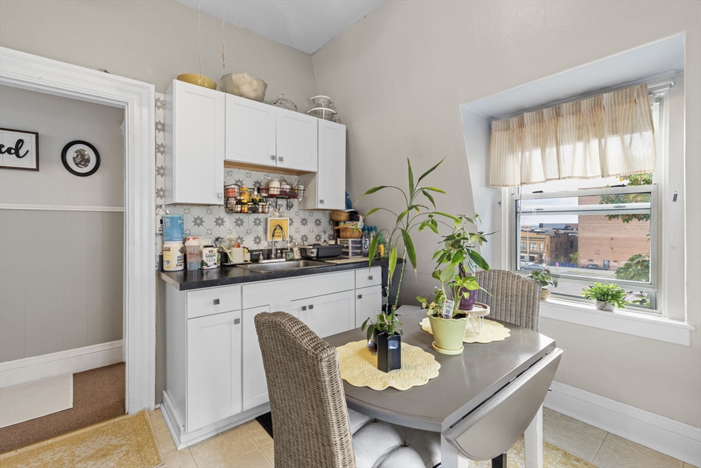 48 Ridge Street Fall River, MA 02721 - Photo 14 of 39 a kitchen with stainless steel appliances granite countertop a dining table chairs and a refrigerator
