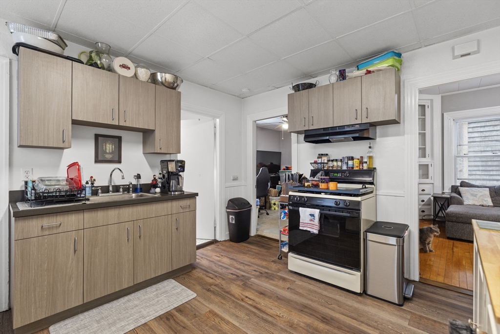 48 Ridge Street Fall River, MA 02721 - Photo 15 of 39 a kitchen with stainless steel appliances a sink cabinets and wooden floor