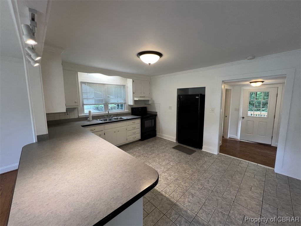 398 Philpot Road Locust Hill, VA 23092 - Photo 8 of 17 Kitchen featuring black appliances, ornamental molding, a sink, dark countertops, and plenty of natural light