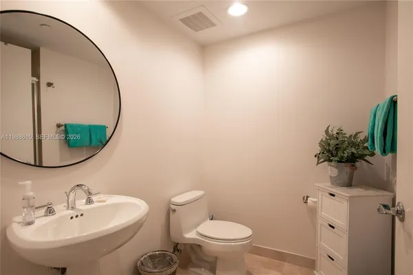 a bathroom with a sink toilet and mirror