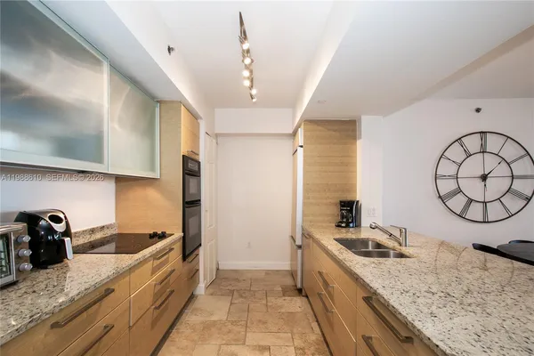 a large kitchen with a lot of counter space and wooden floor