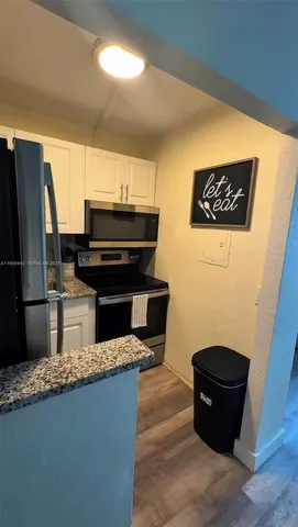 a kitchen with kitchen island a refrigerator sink and stove