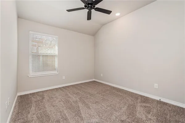an empty room with window and ceiling fan