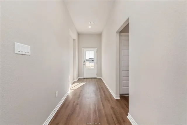 a view of hallway with wooden floor
