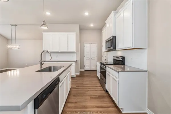 a kitchen with a sink stove and cabinets