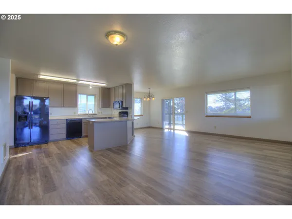 a view of a living room a kitchen and a sink