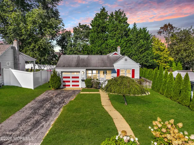 a aerial view of a house next to a big yard and large trees