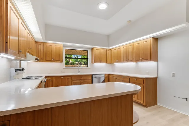 a kitchen with a sink a stove and a wooden cabinets
