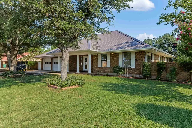 a front view of a house with a garden