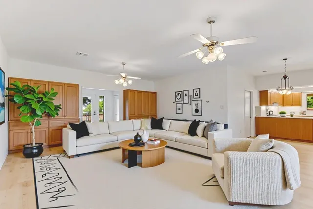a living room with furniture a chandelier and a flat screen tv