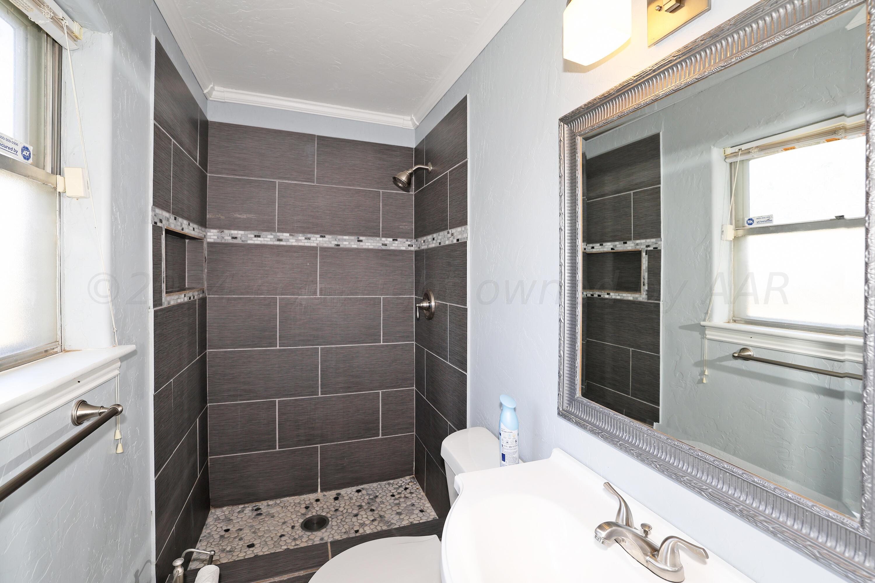 5206 South Travis Street Amarillo, TX 79110 - Photo 13 of 21 a bathroom with a sink toilet and shower