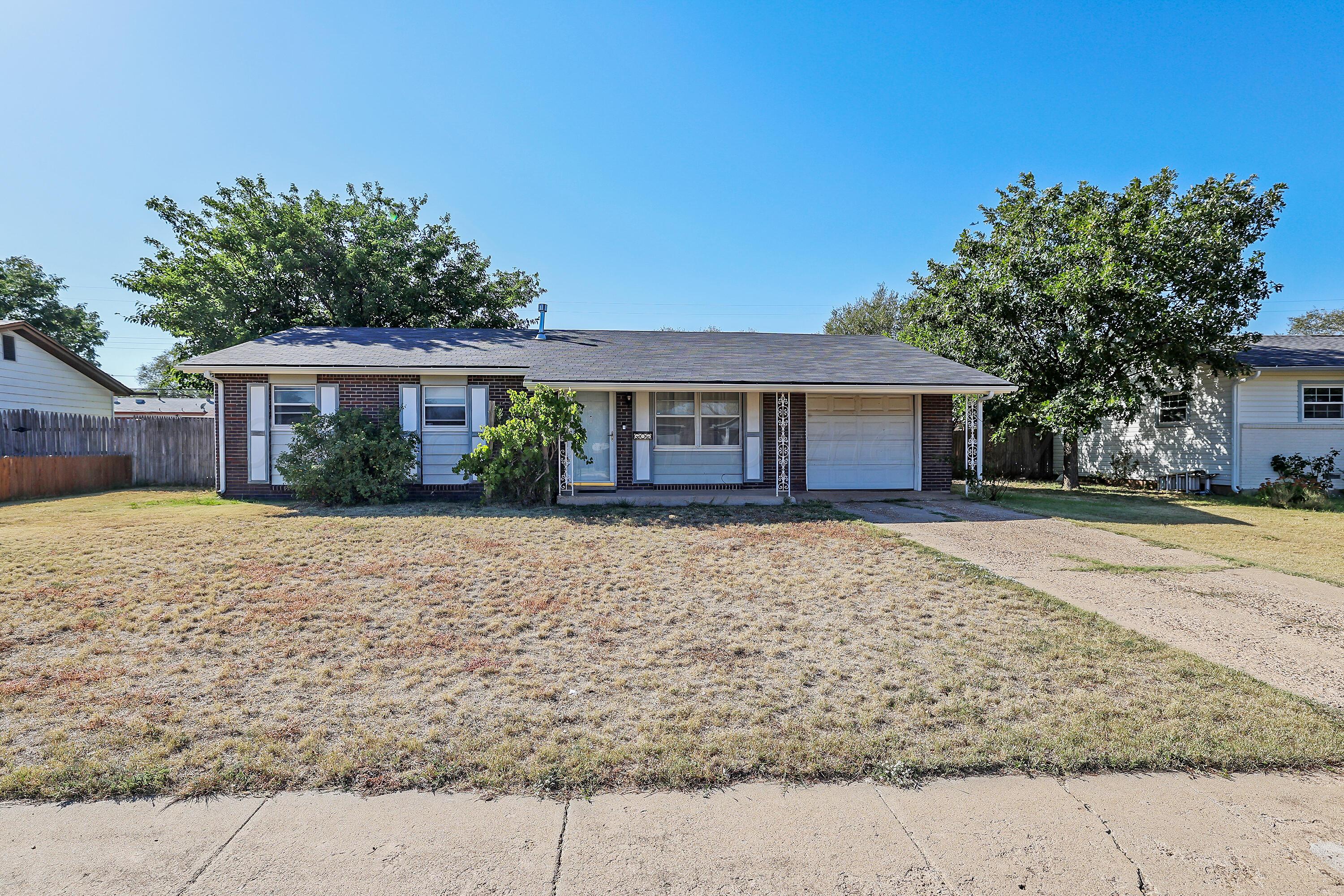 5206 South Travis Street Amarillo, TX 79110 - Photo 2 of 21 a front view of a house with a yard and garage