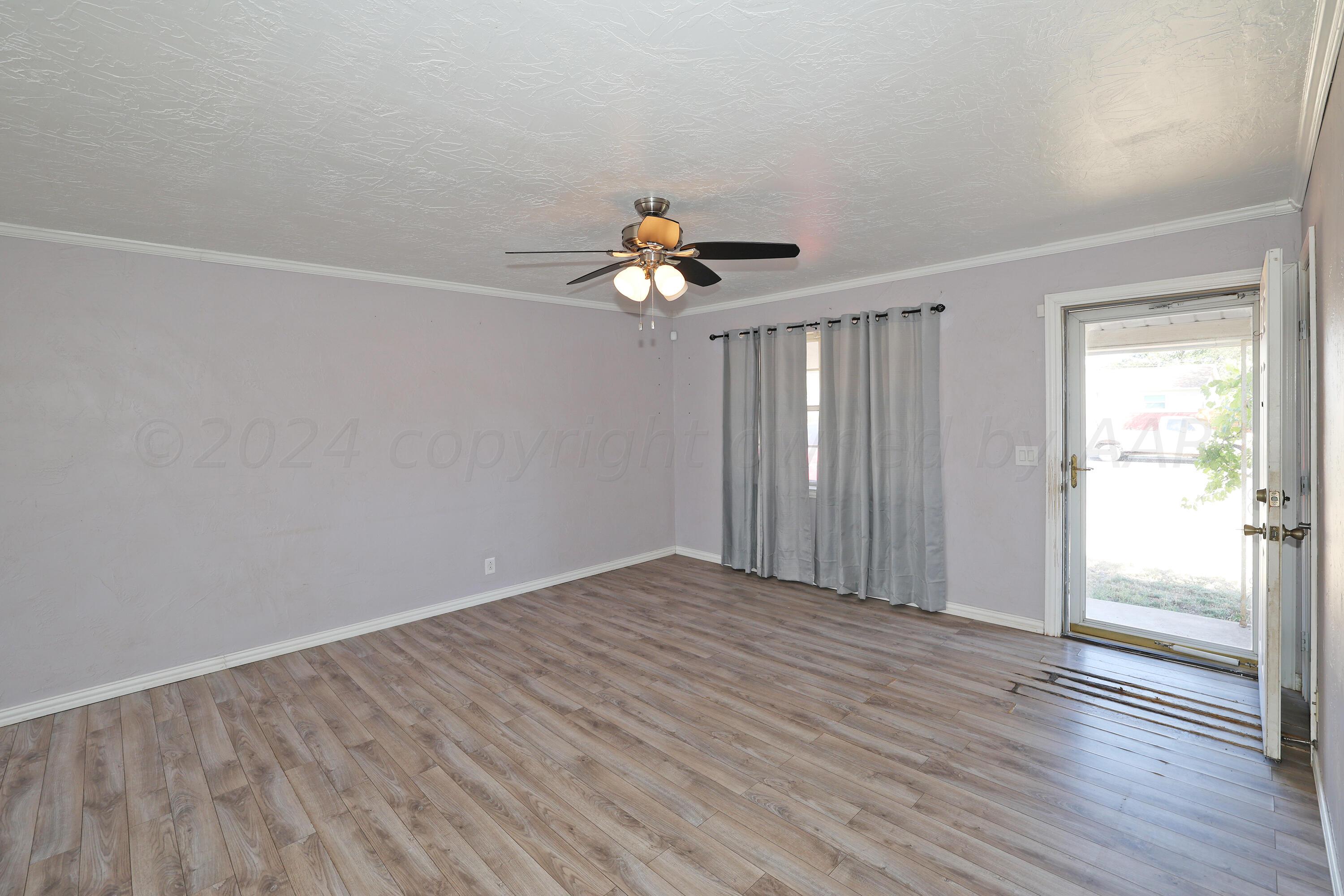 5206 South Travis Street Amarillo, TX 79110 - Photo 5 of 21 a view of an empty room with wooden floor and a window