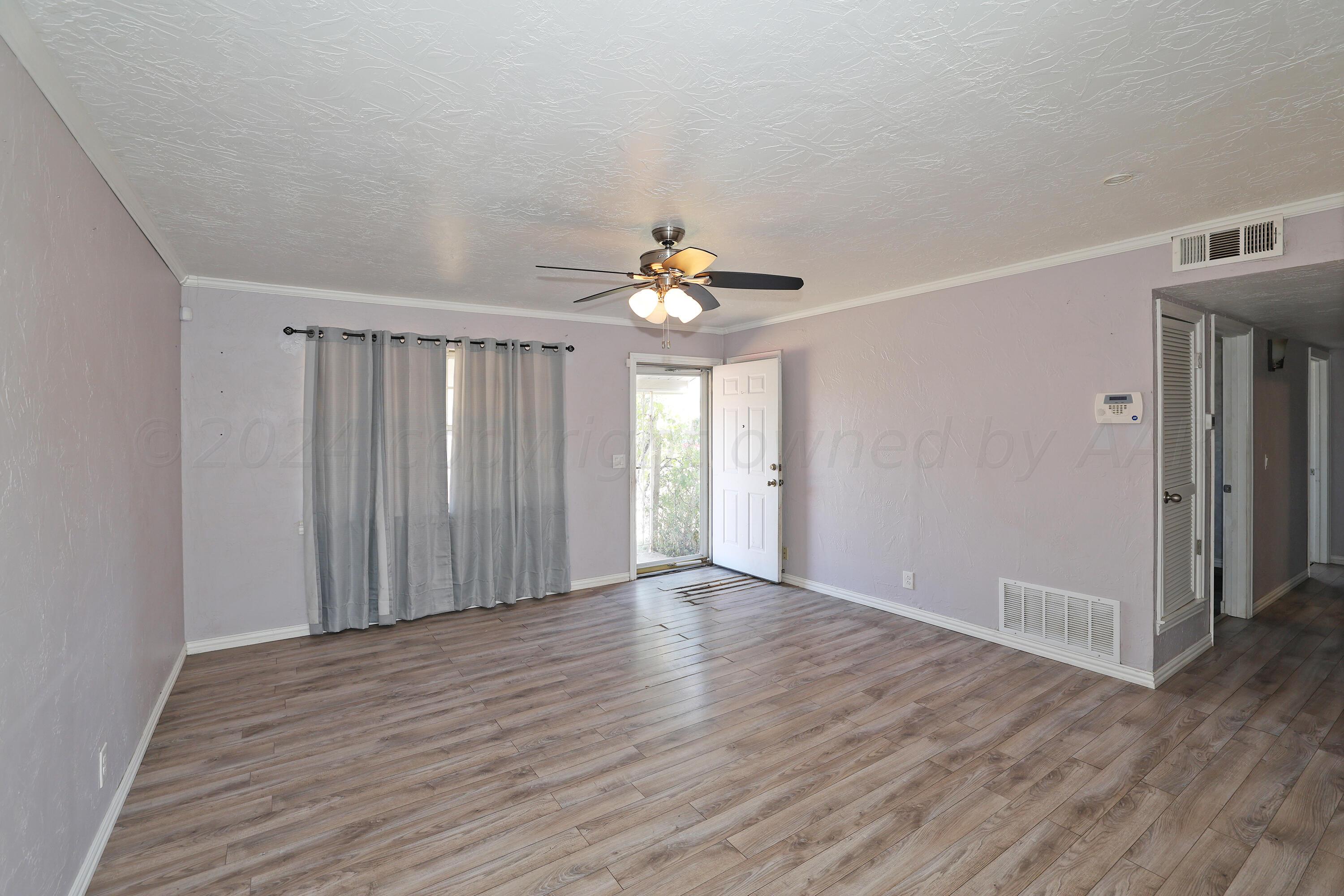 5206 South Travis Street Amarillo, TX 79110 - Photo 6 of 21 a view of an empty room with wooden floor