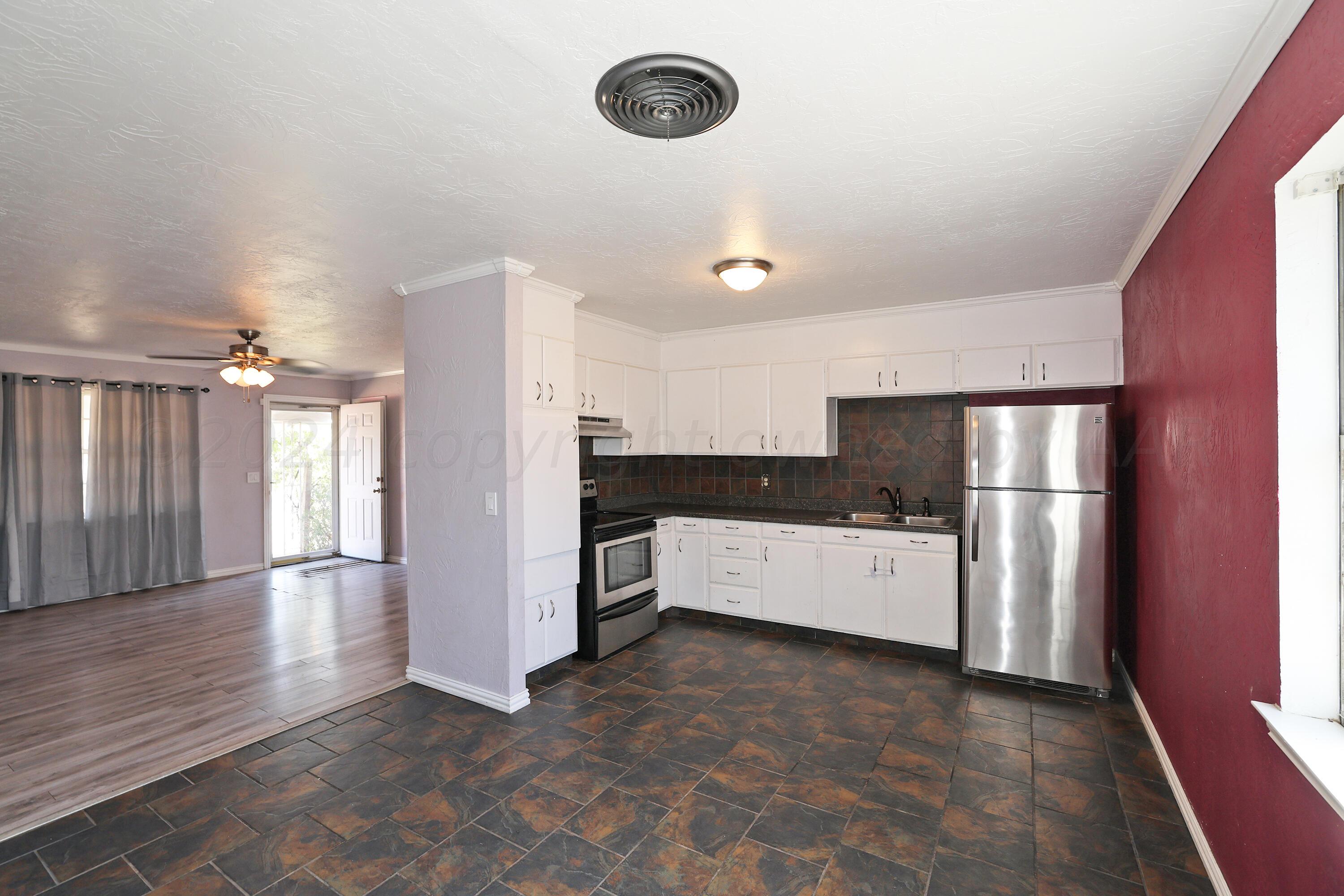5206 South Travis Street Amarillo, TX 79110 - Photo 7 of 21 a large white kitchen with a stove a refrigerator and a stove