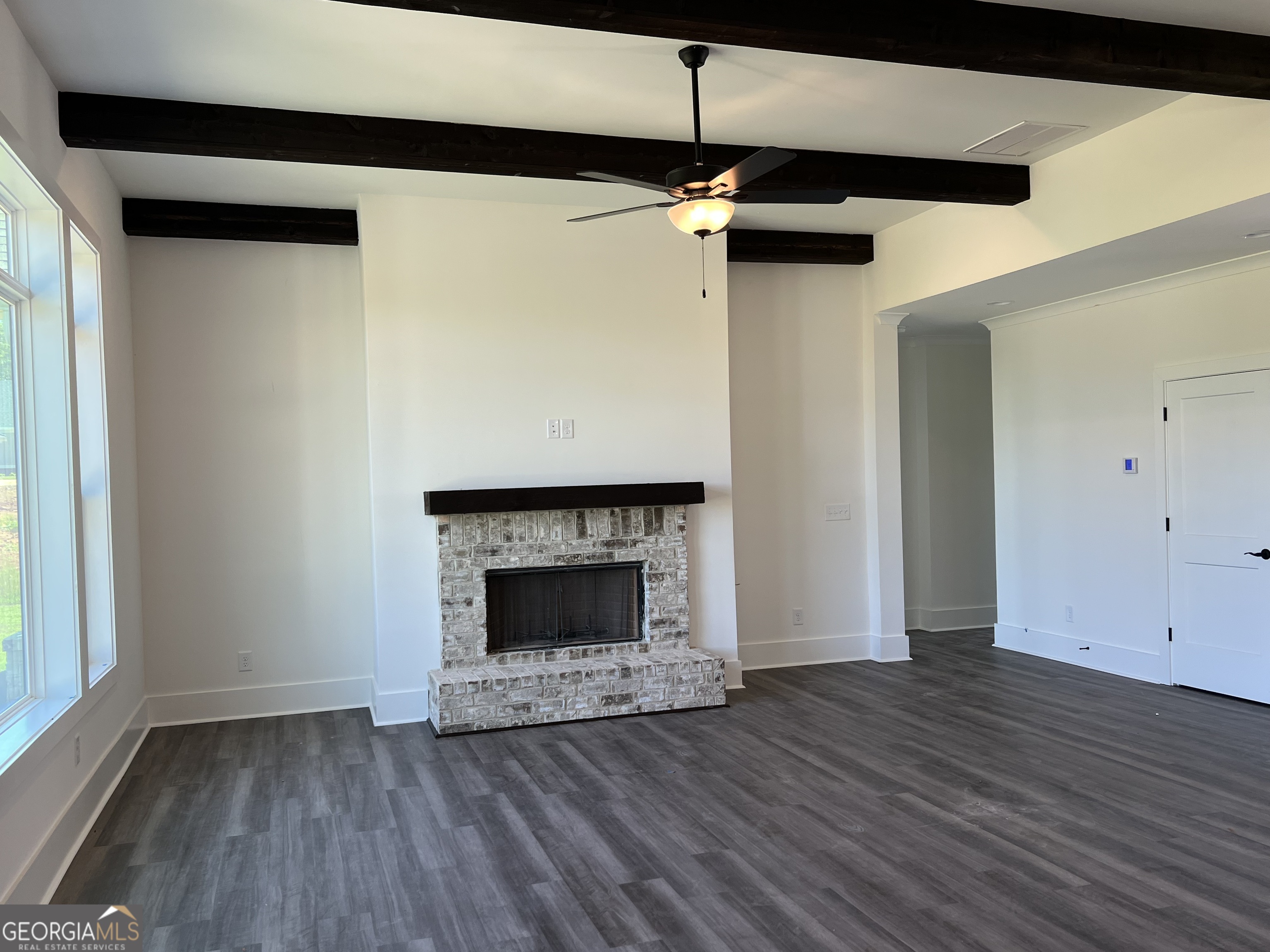 155 Hawthorne Lane Forsyth, GA 31029 - Photo 18 of 46 a view of an empty room with wooden floor fireplace and a window