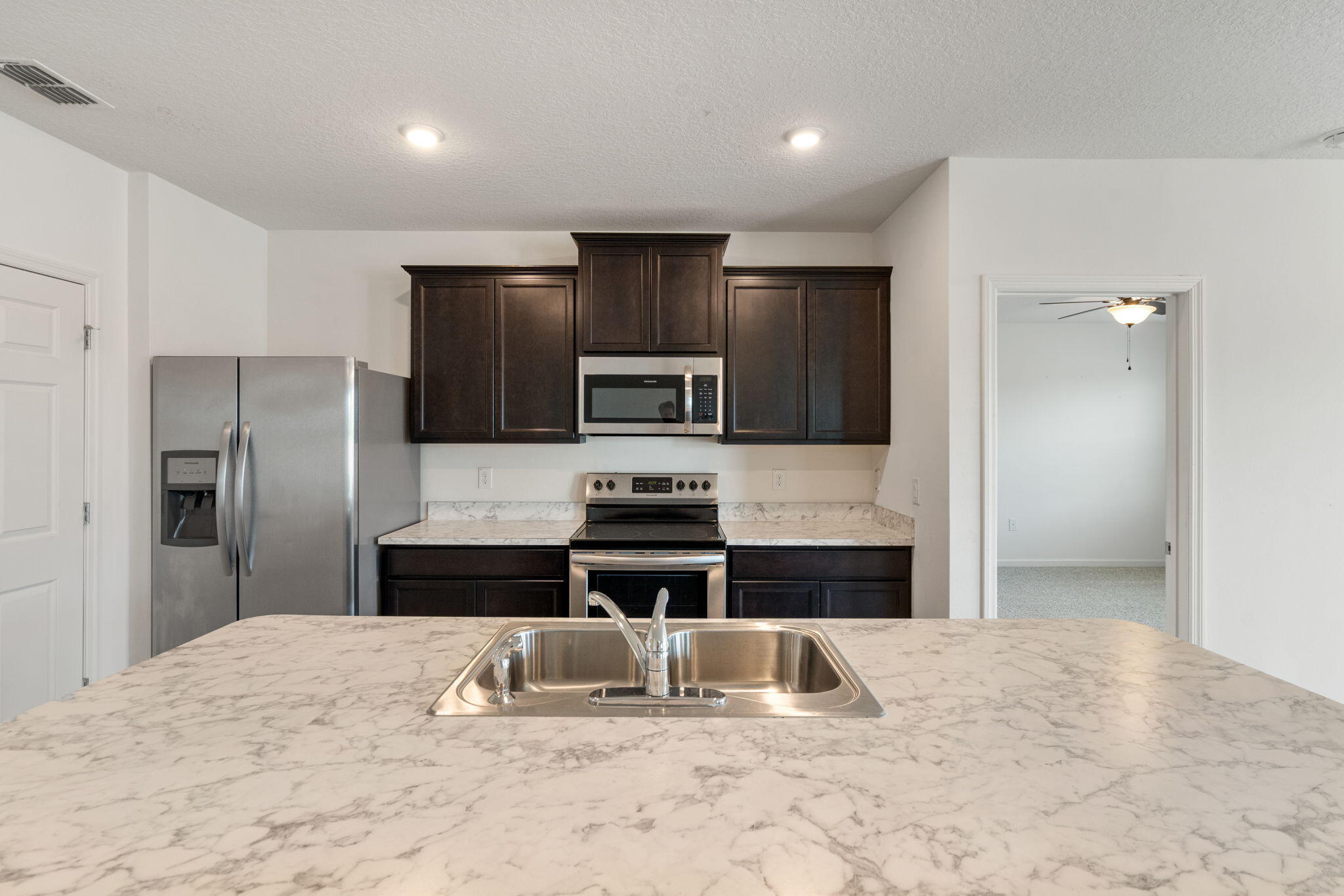 376 Snook Place Cocoa, FL 32927 - Photo 3 of 26 a kitchen with kitchen island stainless steel appliances a refrigerator and a counter top space