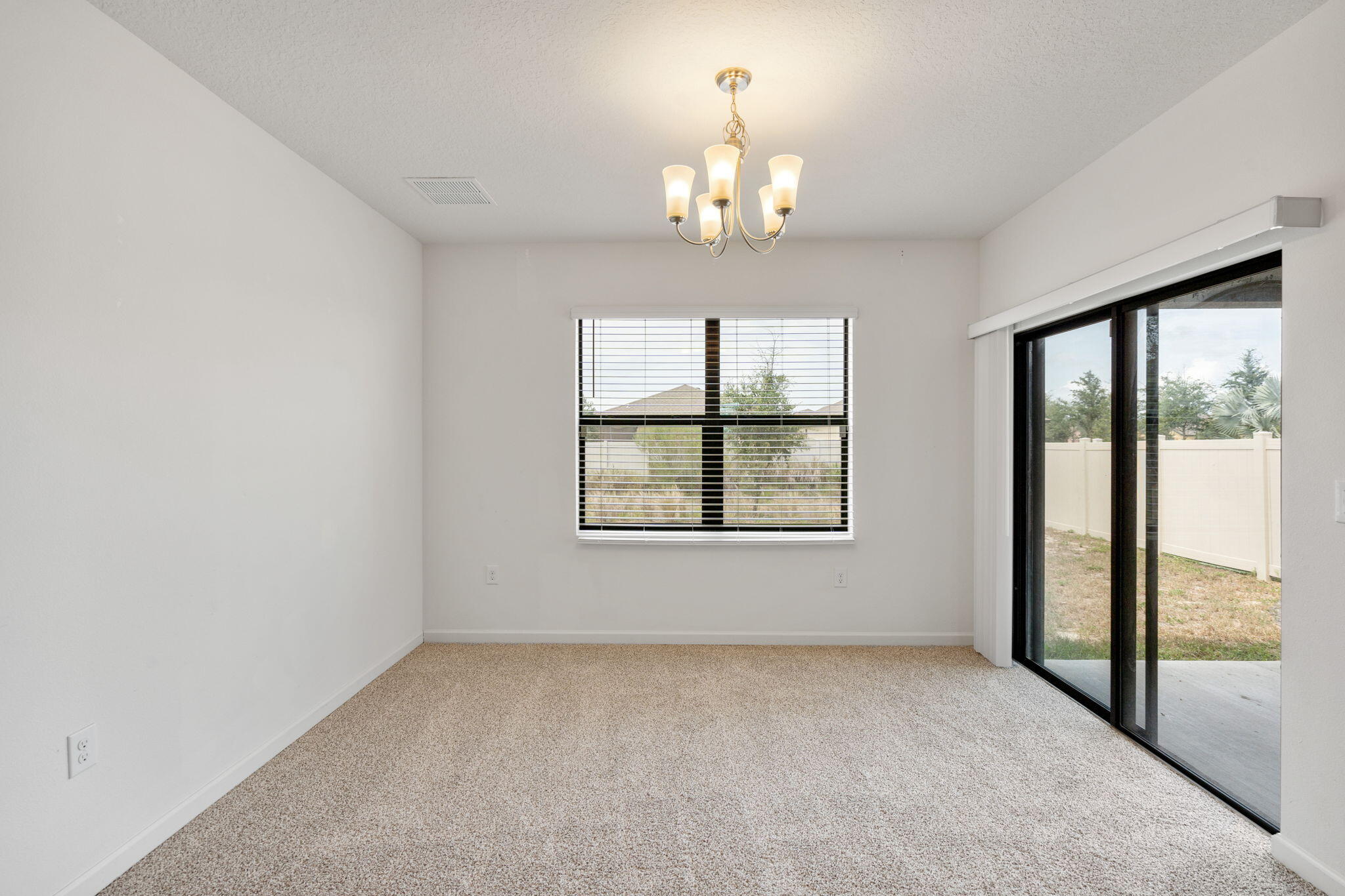 376 Snook Place Cocoa, FL 32927 - Photo 10 of 26 en empty room with windows and chandelier