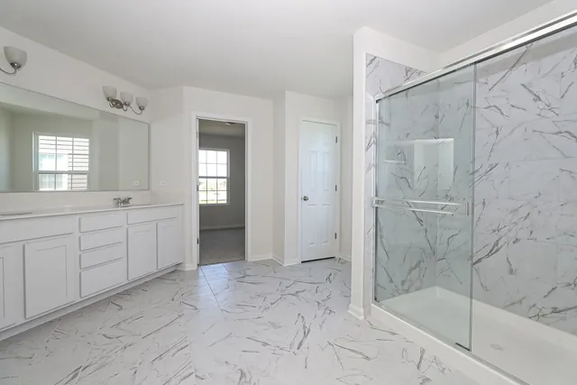 a spacious bathroom with a shower sink and mirror