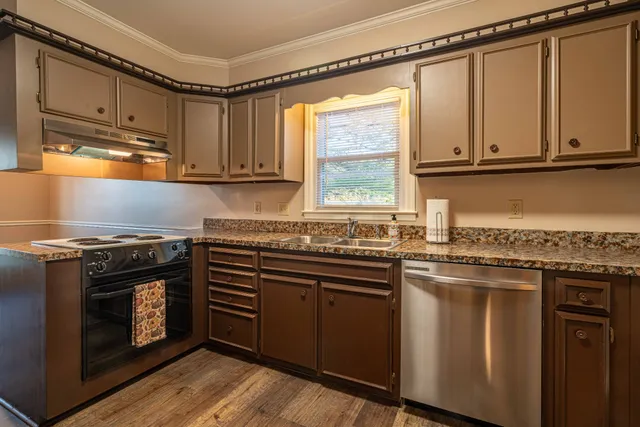 a kitchen with stainless steel appliances granite countertop a stove a sink and a microwave