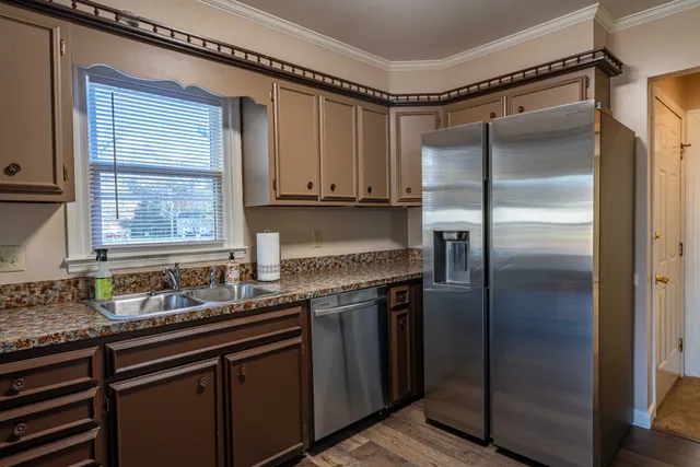 a kitchen with stainless steel appliances granite countertop a refrigerator and a sink
