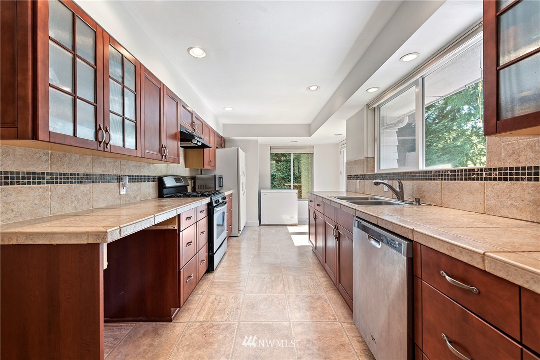 7611 Northeast 12th Street Medina, WA 98039 - Photo 11 of 23 a kitchen with stainless steel appliances granite countertop a sink and a stove