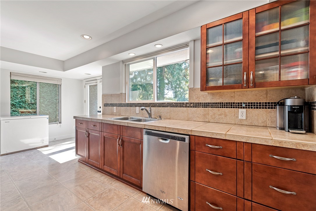 7611 Northeast 12th Street Medina, WA 98039 - Photo 9 of 23 a kitchen with stainless steel appliances granite countertop a sink and a large window